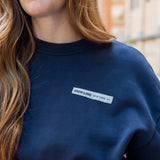 Closeup on High Line New York NY ribbon detail on the front of the Park in the Sky Crewneck Sweatshirt in navy.