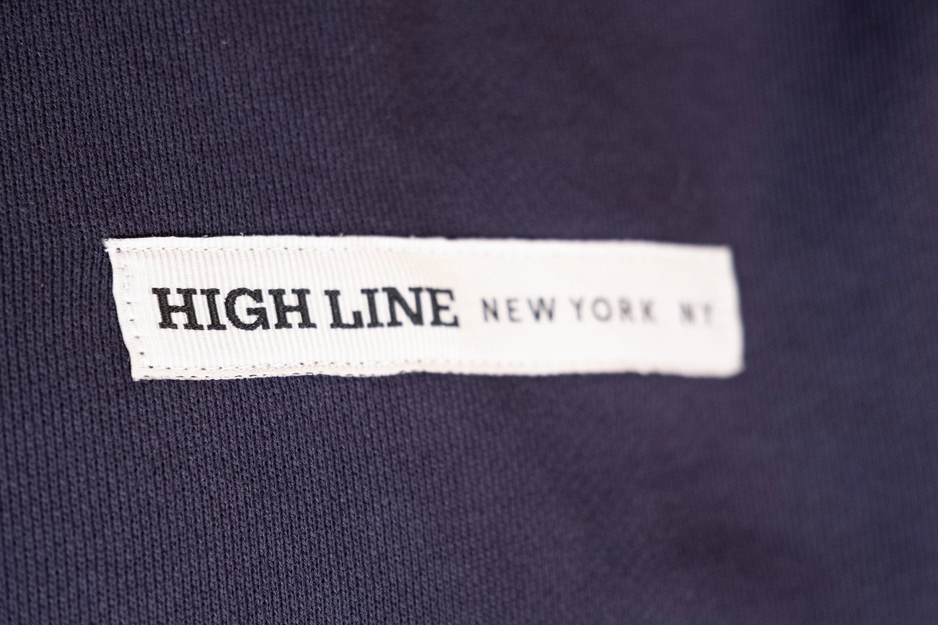 Park in the Sky Crewneck in navy. Close up of chest ribbon detail with the High Line wordmark and "New York NY"