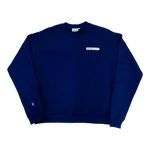 Park in the Sky Crewneck in navy. Front features a chest ribbon detail with the High Line logo and "New York" as well as a small woven patch with the High Line railroad track-inspired "H" icon sewn on the right sleeve. The navy is a deep, saturated blue.