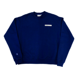Park in the Sky Crewneck in navy. Front features a chest ribbon detail with the High Line logo and "New York" as well as a small woven patch with the High Line railroad track-inspired "H" icon sewn on the right sleeve. The navy is a deep, saturated blue.