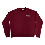 Park in the Sky Crewneck in Smokebush. Front features a chest ribbon detail with the High Line logo and "New York NY" as well as a small woven patch with the High Line railroad track-inspired "H" icon sewn on the right sleeve. Smokebush is a deep, burgundy red.