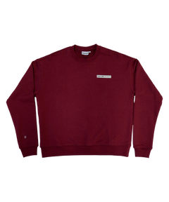 Park in the Sky Crewneck in Smokebush. Front features a chest ribbon detail with the High Line logo and "New York NY" as well as a small woven patch with the High Line railroad track-inspired "H" icon sewn on the right sleeve. Smokebush is a deep, burgundy red.