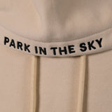 Park in the Sky embroidered hoodie in River Birch. Closeup of "PARK IN THE SKY" embroidered on the hood along the seam.
