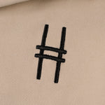Front chest embroidery detail with High Line icon in black against the River Birch fabric.