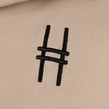 Front chest embroidery detail with High Line icon in black against the River Birch fabric.