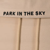 Park in the Sky embroidered hoodie in River Birch. Closeup of "PARK IN THE SKY" embroidered on the hood along the seam.
