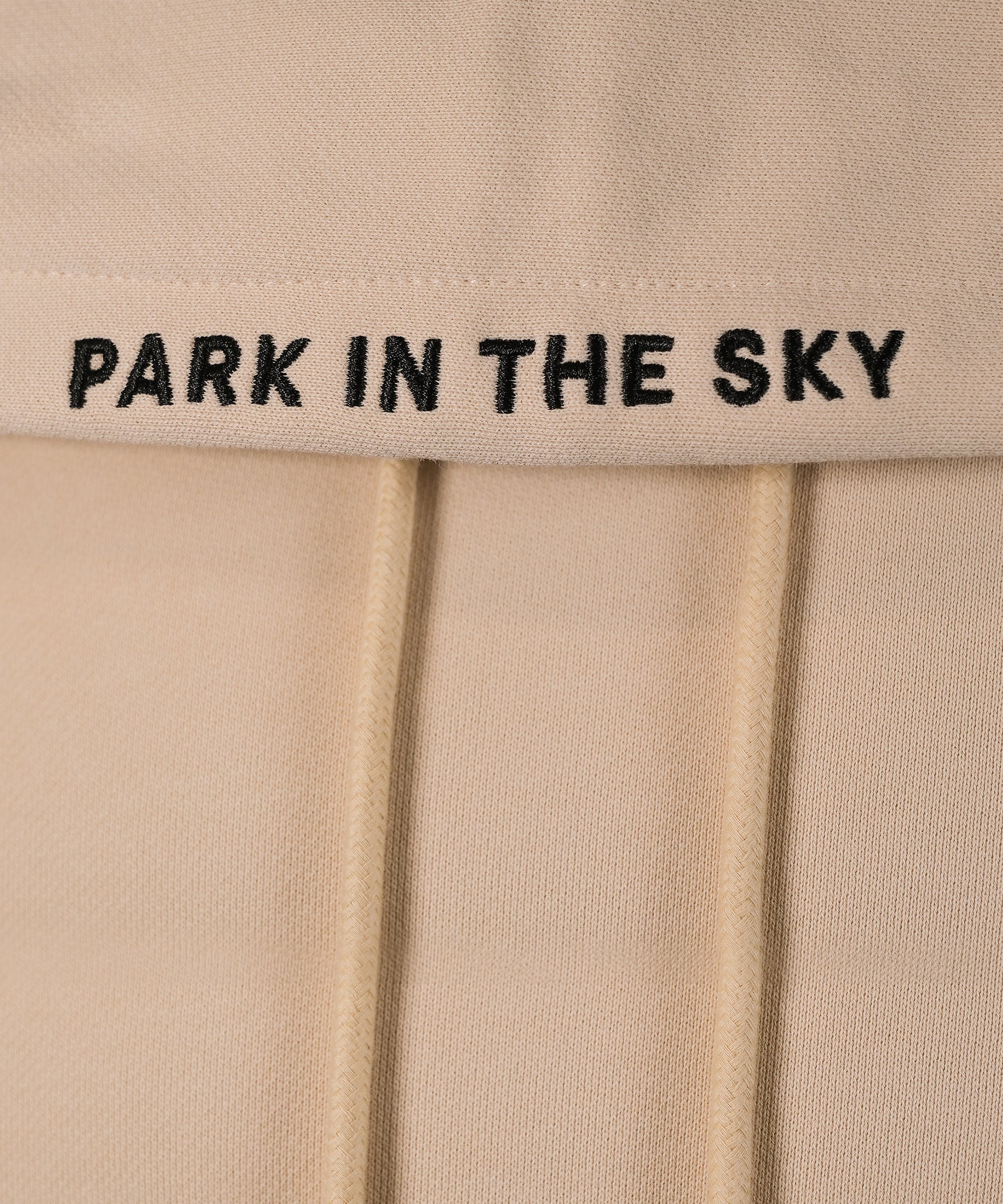 Park in the Sky embroidered hoodie in River Birch. Closeup of "PARK IN THE SKY" embroidered on the hood along the seam.