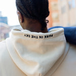 Woman wearing Park in the Sky crewneck and man in the Park in the Sky hoodie, with embroidery on the hoodie visible.