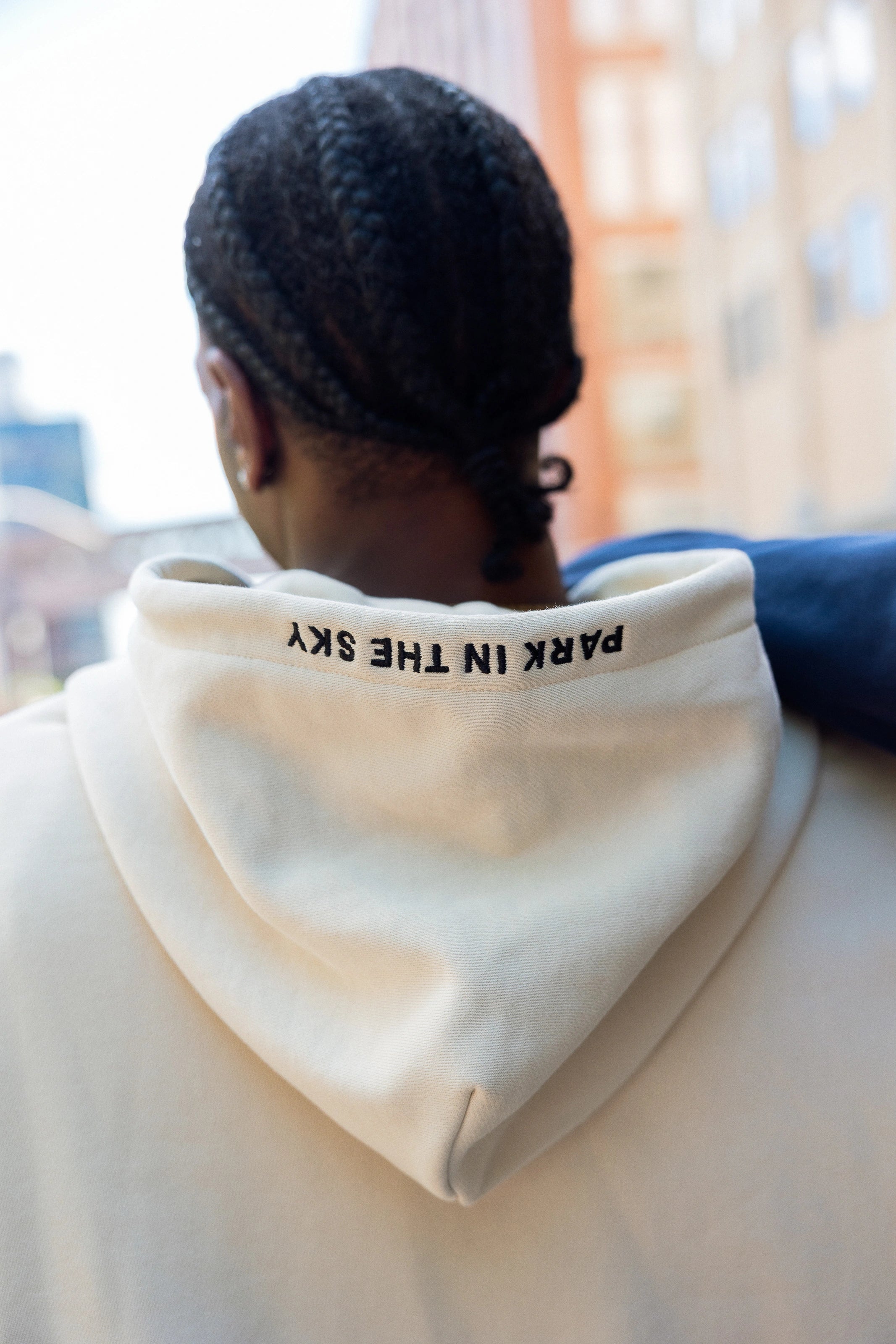 Woman wearing Park in the Sky crewneck and man in the Park in the Sky hoodie, with embroidery on the hoodie visible.