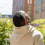 Man wearing the Park in the Sky Hoodie with hood embroidery detail visible, looking up and feeling the sun on his face.