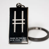 Black rectangular enamel keychain with the High Line railroad-track "H" icon and "Park in the Sky, New York NY" on a white background.