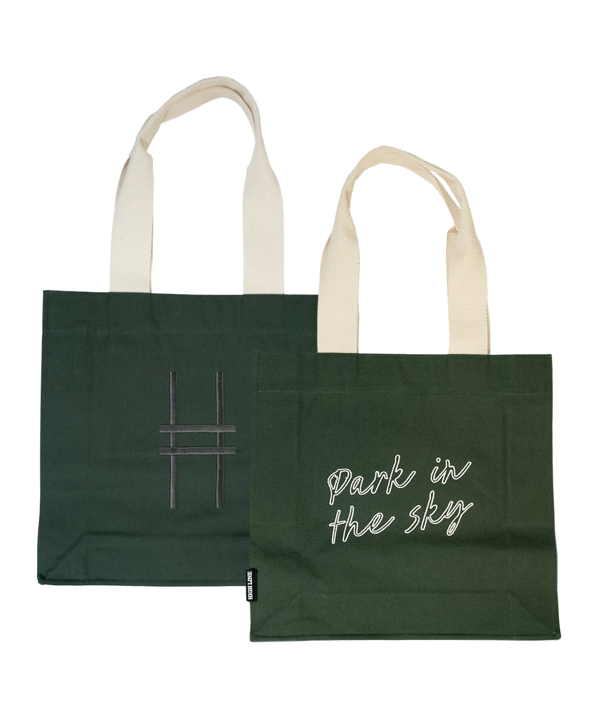 Both sides of the Park in the Sky Tote in Ivy—one side features the tagline "park in the sky" embroidered in white and the other the railroad track "H" icon embroidered in dark green against the dark Ivy green canvas with natural straps.