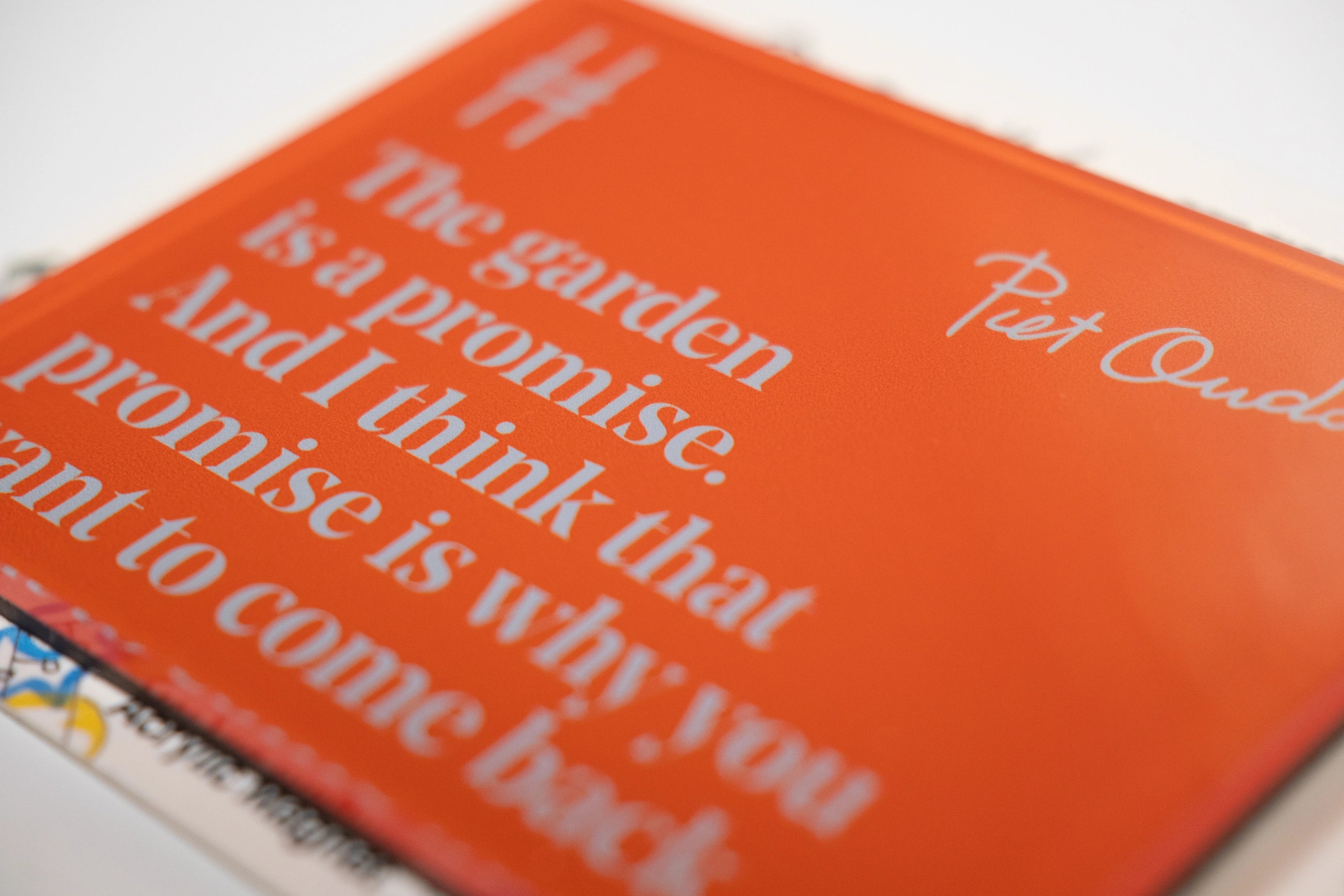 Acrylic fridge magnet featuring the quote "The garden is a promise. And I think that promise is why you want to come back." in pale blue against rich orange, with Piet Oudolf's signature and the High Line icon.