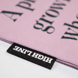 Closeup of the Piet Oudolf Quote Tote in Aster, showing the High Line tag and part of the quote.
