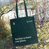 Piet Oudolf quote tote in Ivy, featuring the quote "You have to know your plants" being held up against the foliage of the High Line.