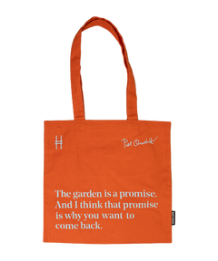 Piet Oudolf Quote Tote in Trumpet Honeysuckle—an orange cotton canvas tote bag featuring the quote "The garden is a promise. And I think that promise is why you want to come back." The quote, Oudolf's signature, and the High Line icon are all in a pale sky blue.