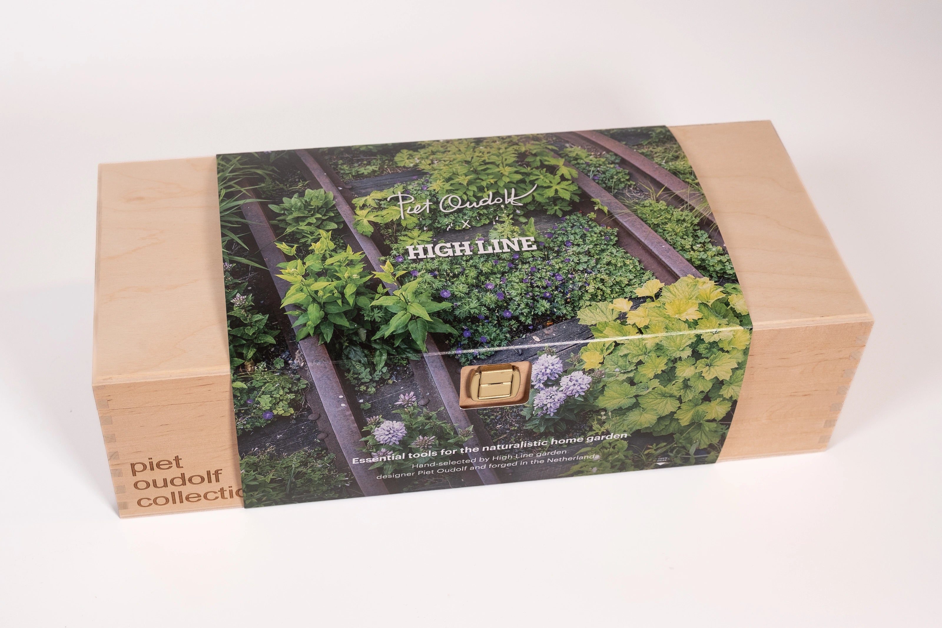Tool box containing the City Gardener Essential Tool Kit, wrapped in an image of the High Line with "Piet Oudolf x High Line" overlaid on it. The box is embossed with "piet oudolf collection".