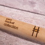 Ash handle of the Sneeboer Handspade, closeup of the embossed "Piet Oudolf collection" and High Line railroad-track "H" icon.