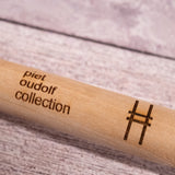 Ash handle of the Sneeboer Handspade, closeup of the embossed "Piet Oudolf collection" and High Line railroad-track "H" icon.