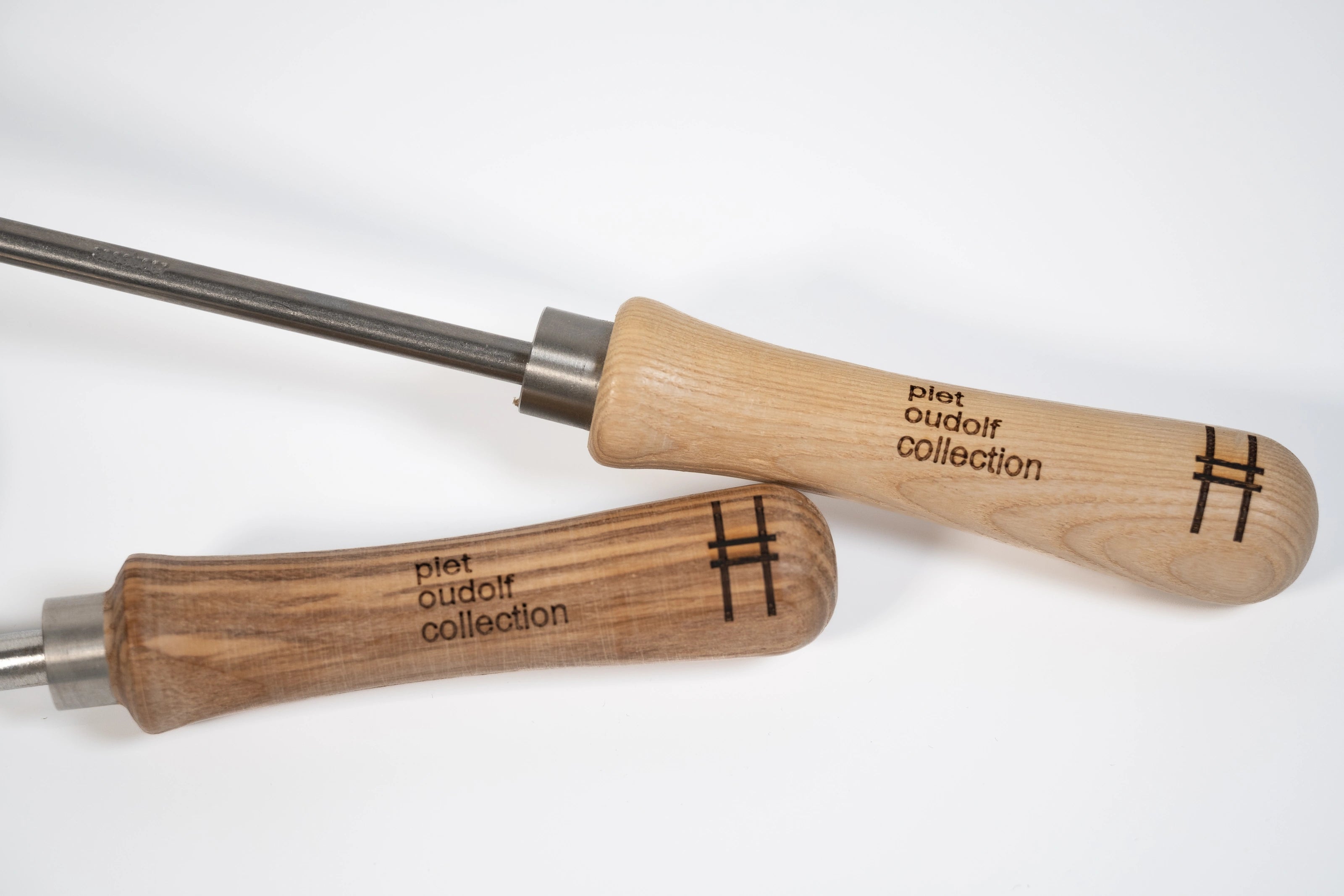 Sneeboer trowel and hand hoe with High Line icon and "Piet Oudolf collection" embossed on the wood handles—closeup of the handles.