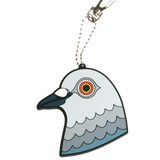The Dinosaur head bag charm. A stylized PVC rubber bag charm shaped like a pigeon head. It is attached to a silver ball chain and a silver carabiner clip, shown on a plain white background.