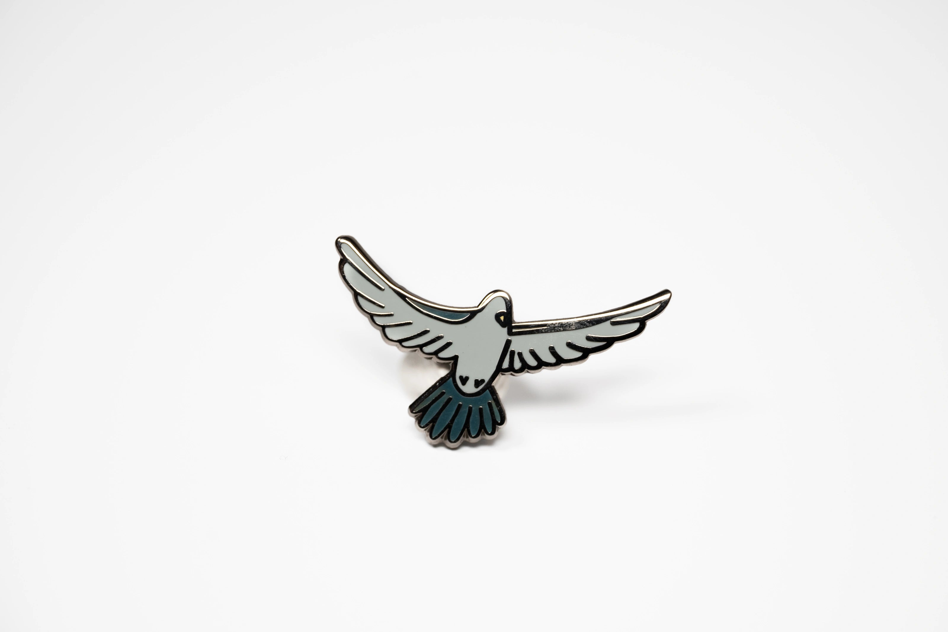 Pigeon in flight enamel pin.