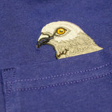 Closeup of Pigeon head embroidery popping out of the pocket on the Pigeon Pocket long-sleeve tee in Navy a rich, saturated, dark blue.