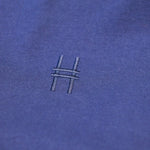 Closeup of the High Line icon, a railroad track inspired "H" embroidered on the Pigeon Pocket Longsleeve Tee in Navy.