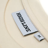 Closeup of the branded neck tag and size tag, as well as the ribbing at the neck of this long-sleeve crewneck t-shirt.