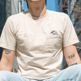 Person wearing the Pigeon Pocket tee, their legs and face cropped out so we focus on their torso and the embroidery details.