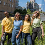 Four people in Protect Pollinators Tees standing amongst the foliage on the High Line, smiling and laughing.