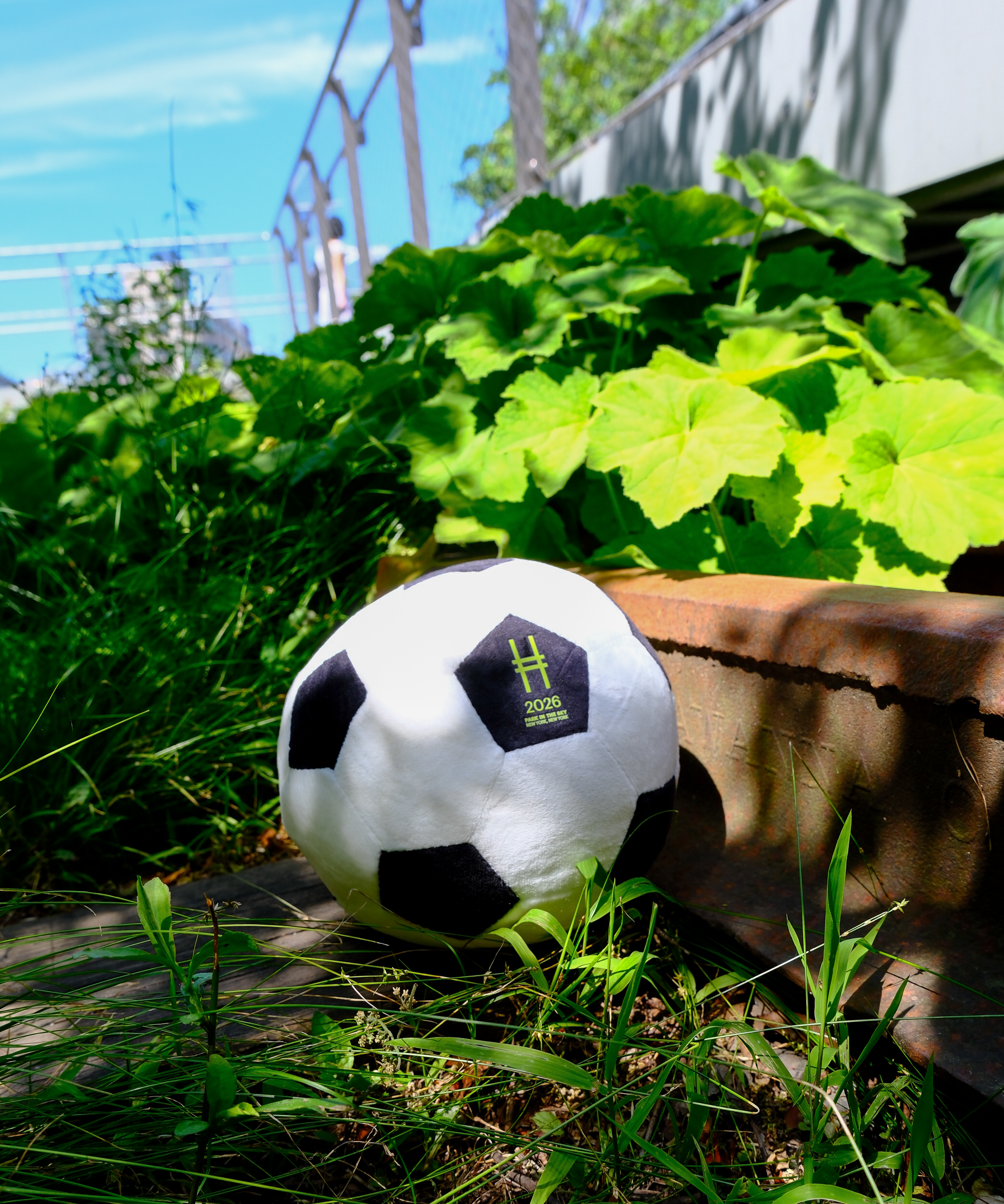 Stuffed soccer ball plush against the rail tracks on the High Line.