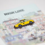 Yellow taxi pin against the backing card featuring Jiaqi Wang's Nature in the City mural.