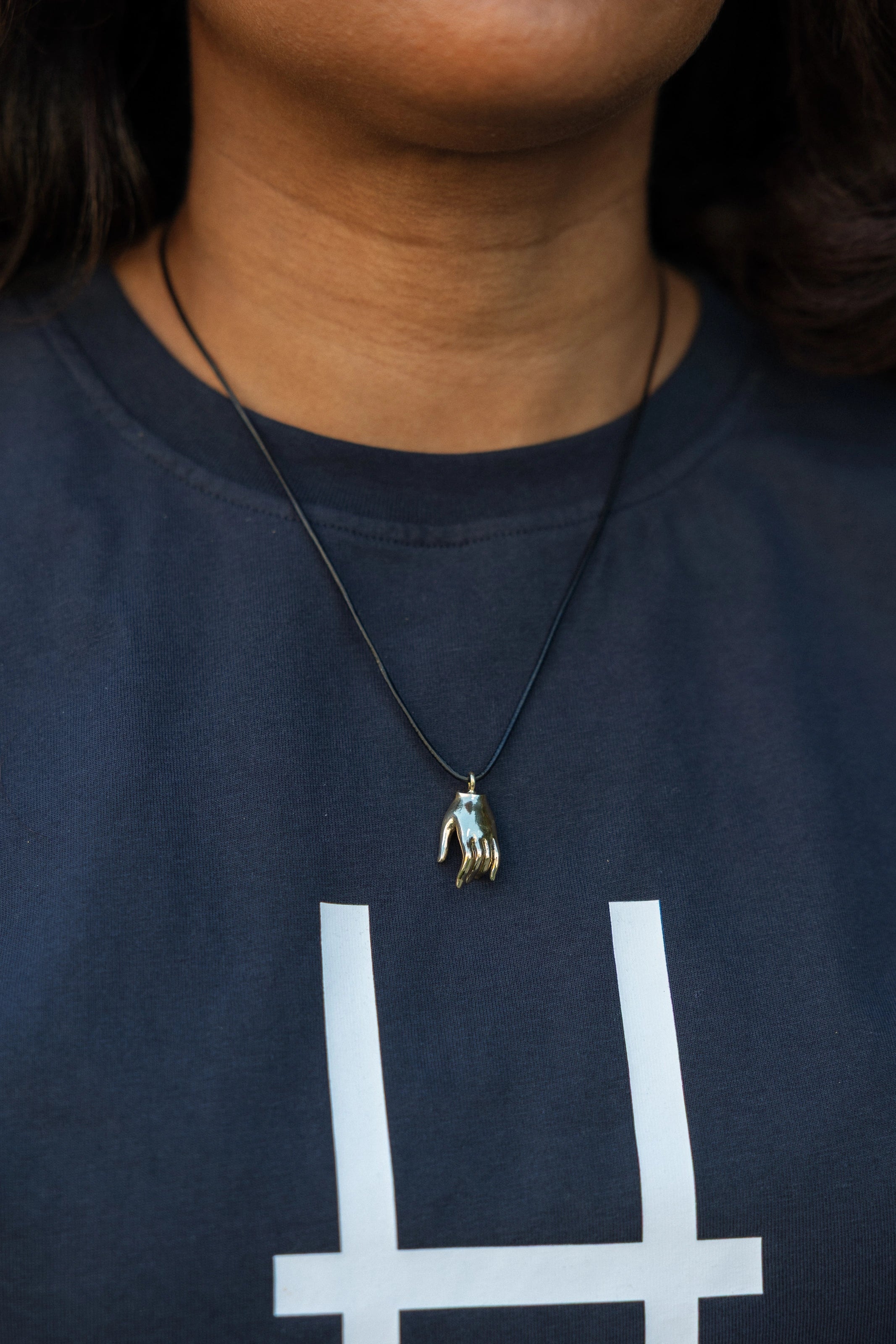 Varada mudra pendant on a woman's neck.