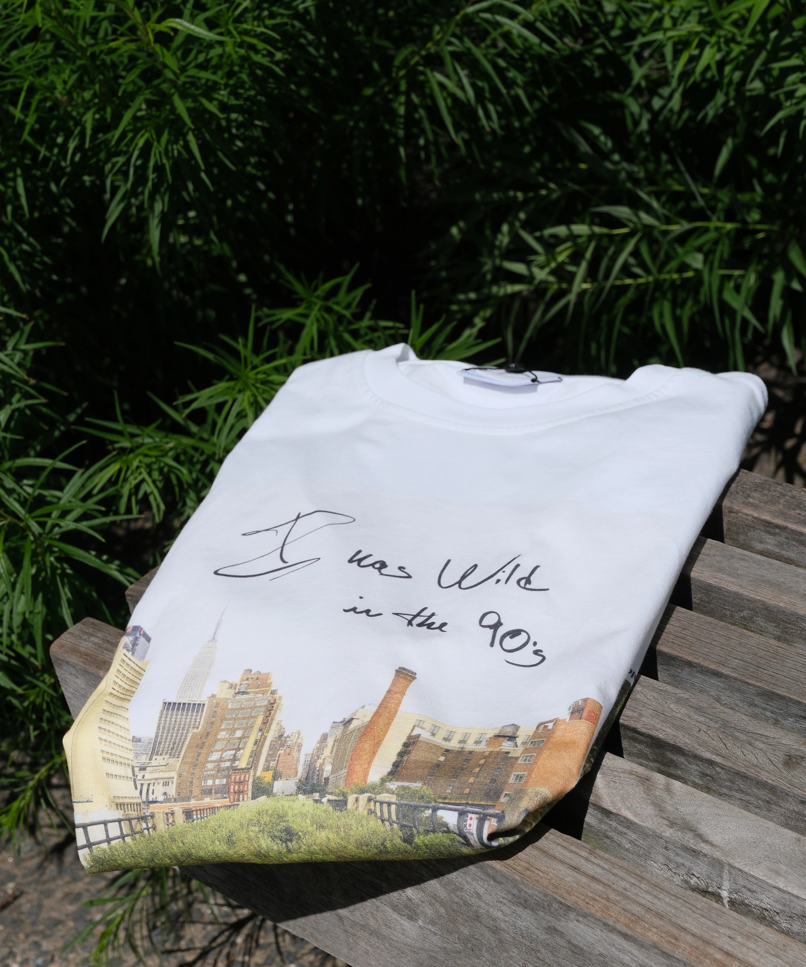 Wild in the 90s Tee folded and resting on one of the benches on the High Line.