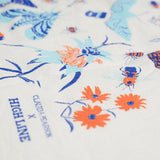 Claudia Pearson x High Line Wildflower Field tea towel, shown in detail. The flour sack cotton tea towel is covered in illustrations of butterflies, ladybugs, moths, other insects and wildflowers in blues and oranges. The logo for the collaboration appears at the bottom.